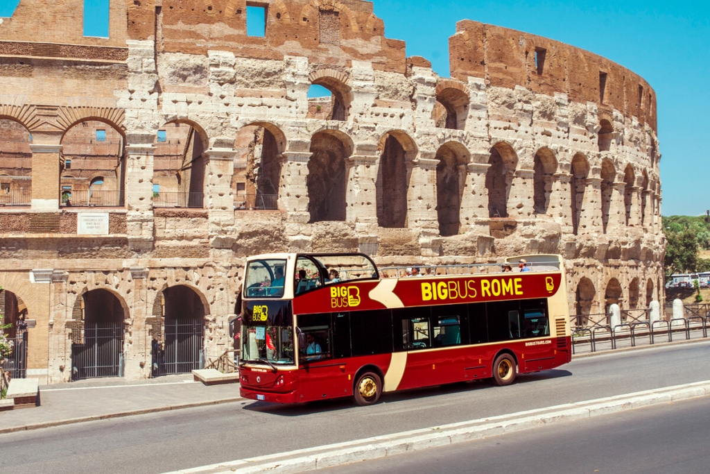 Vue d'un bus hop-on hop-off devant le Colisée à Rome