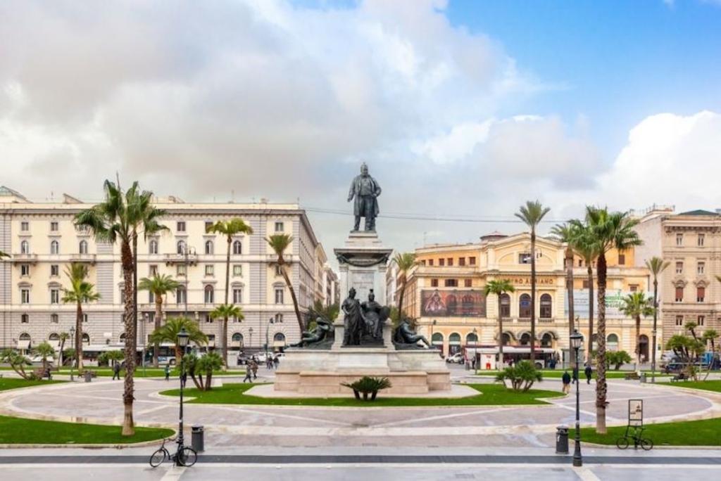 Piazza Cavour à Rome avec des palmiers et de la verdure. Une statue se trouve au centre